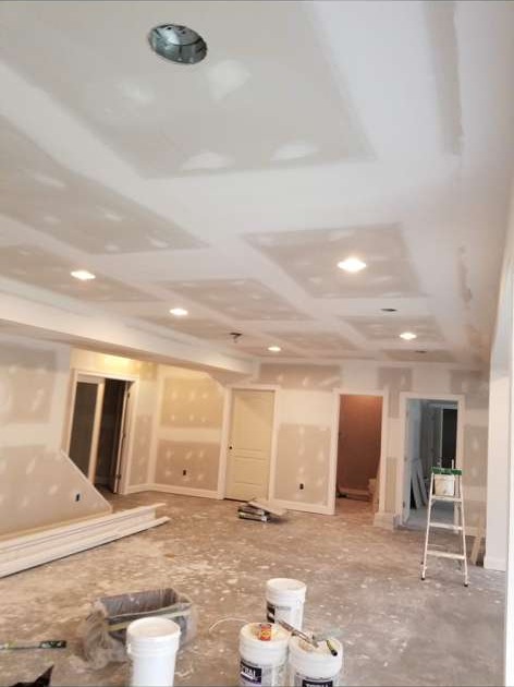 Basement finishing in progress with completed drywall and recessed lighting